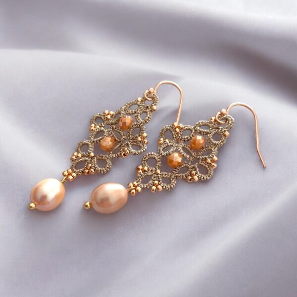 Boucles d’oreilles pendantes en acier inoxydable plaqué or, réalisées à la main selon la technique de la frivolité avec perles de culture roses.