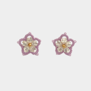 Boucles d'oreilles artisanales en forme de fleur, fabriquées à la main selon la technique de la frivolité, associant fil polyester mauve et véritable nacre blanche façonnée en pétale, incarnant élégance et raffinement.