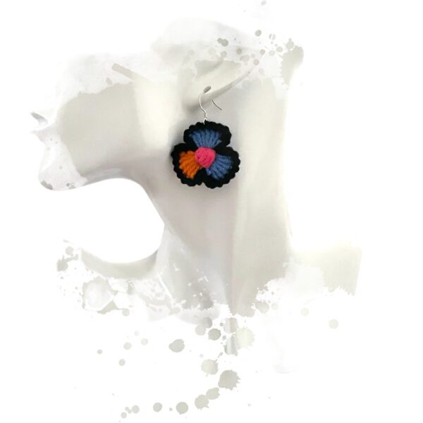 Boucles d'oreilles crochetées, portées, en forme de fleur aux couleurs orange, bleu, noir et rose, avec crochets argentés